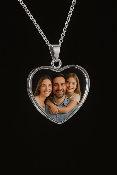 Heart-shaped transparent crystal necklace with photo of father, mother, and daughter on black background