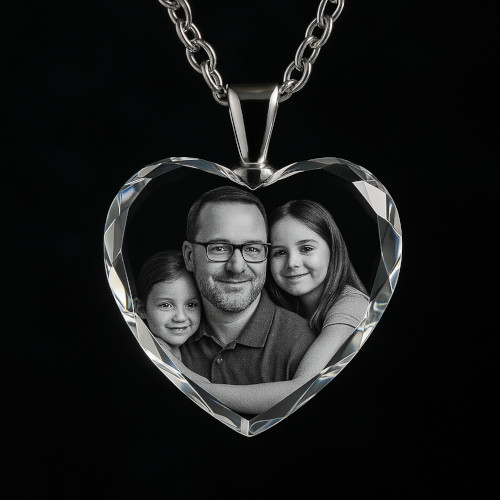 Heart-shaped crystal necklace with engraved photo of father and daughters on a silver chain, set against a dark background.